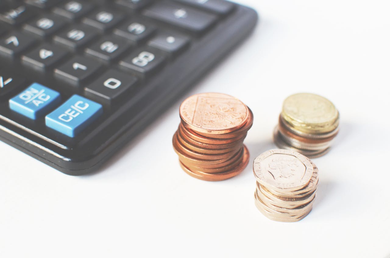 services-03 Close-up of stacked coins and a calculator symbolizing financial strategy and budgeting.
