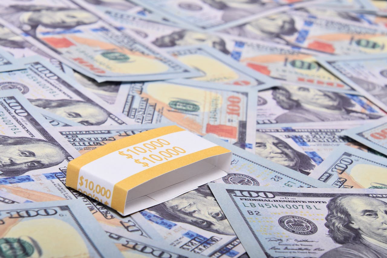 about-img A stack of $100 bills arranged on a surface with US dollar notes. Ideal for finance themes.